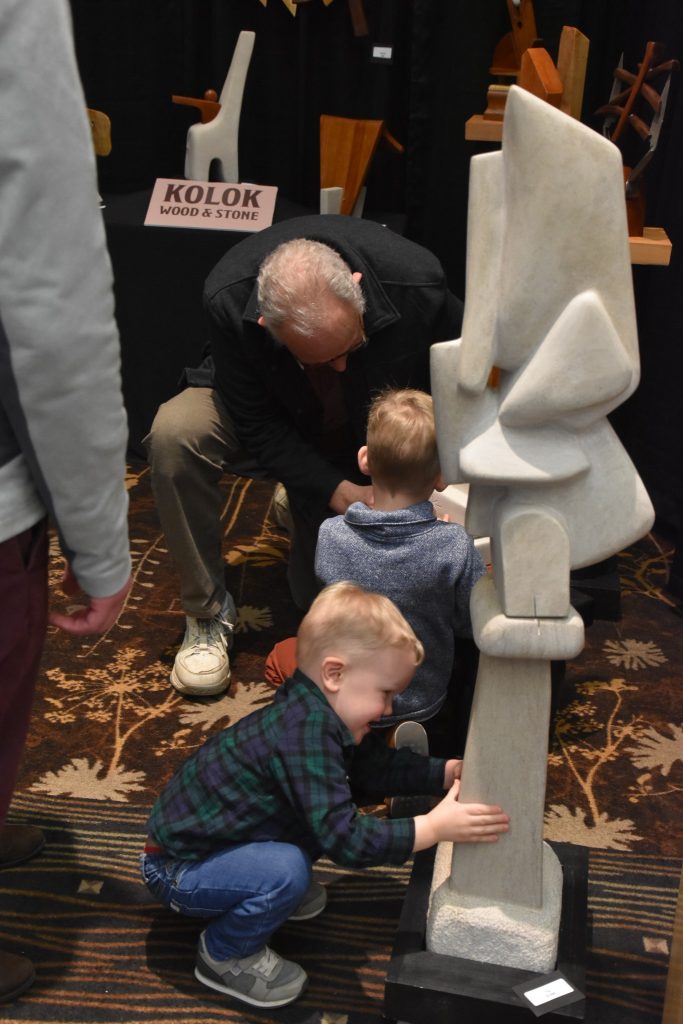 Sculptor Bill Kolok encouraging Leam and Logan to touch the sculptures texture. This was the boys first time at the art fair.