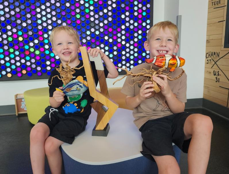 Liam and Logan showing off their art collection from the For the Love of Art Fair.